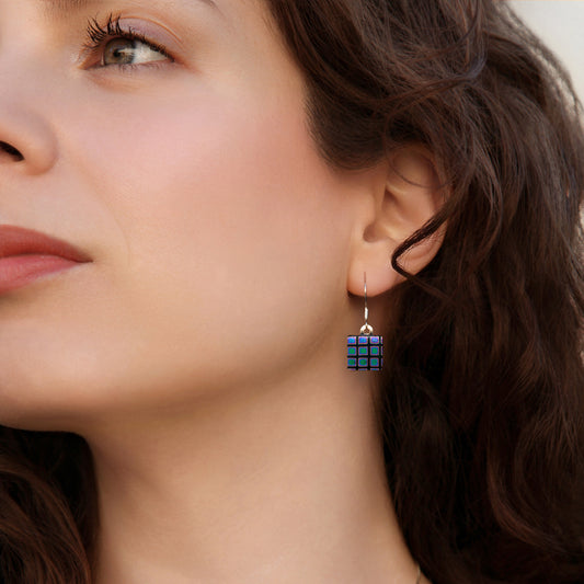 Close-up of a woman wearing a unique earring with a geometric design.