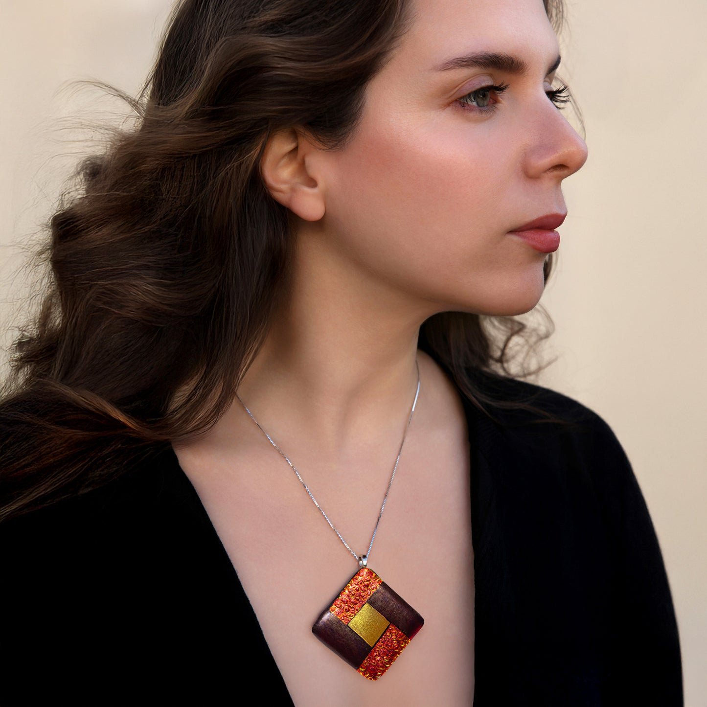 Model wearing Elementa Fire necklace by Invoke London with bold red-gold fused glass pendant symbolising energy and courage.