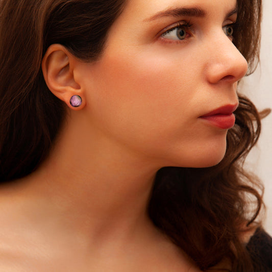 Close-up of a woman wearing a pink earring with a neutral background