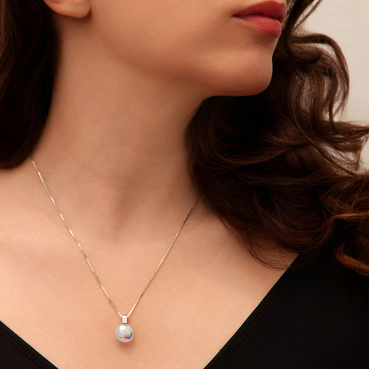 Close-up of Luna June necklace pendant featuring a round pearlescent dichroic glass cabochon with radiant colour-shift glow.