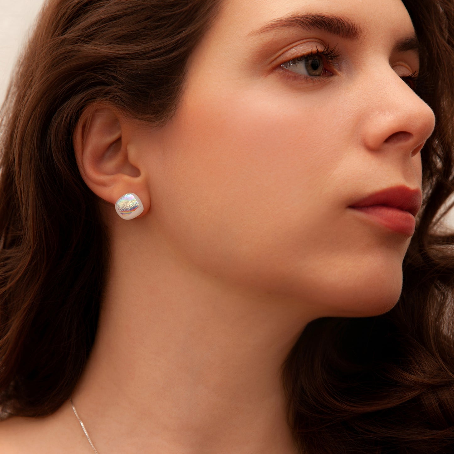 Close-up of Luna June pearlescent dichroic glass cabochon earrings, showing rainbow colour shifts and fine handcrafted details.