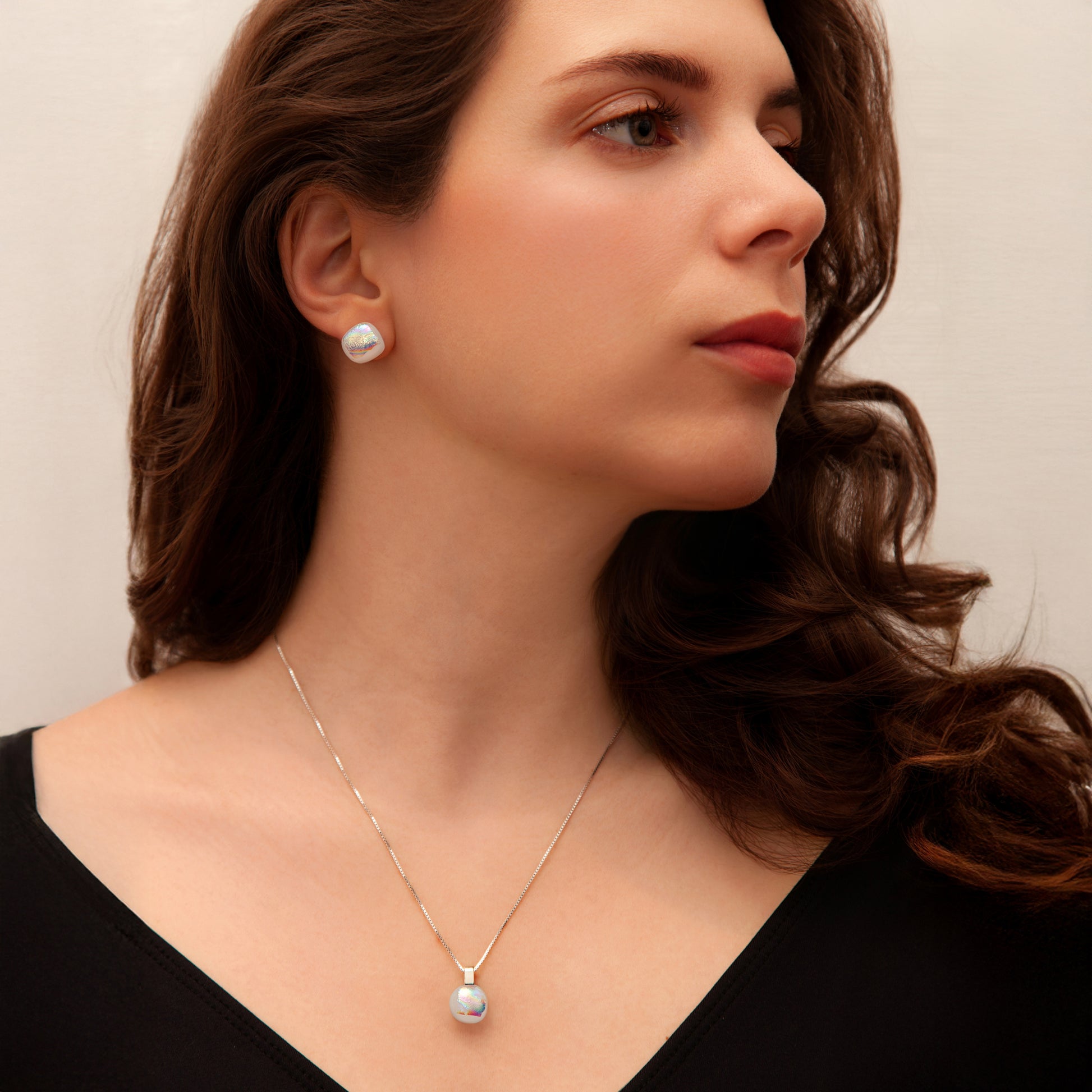 Model wearing pearlescent Luna birthstone jewellery set featuring round stud earrings and matching pendant.