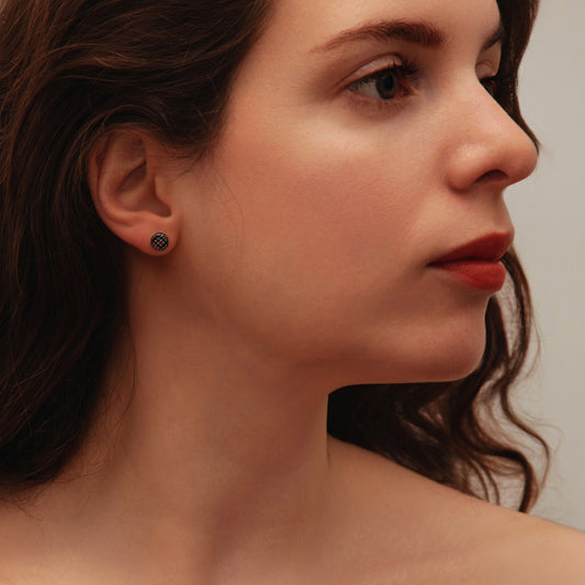 Close-up of a woman wearing an earring with red squares