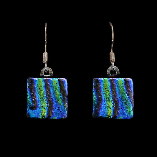 Handmade square drop earrings featuring fused dichroic glass with bold green and blue ripple textures, part of the Astra Collection by Invoke London.