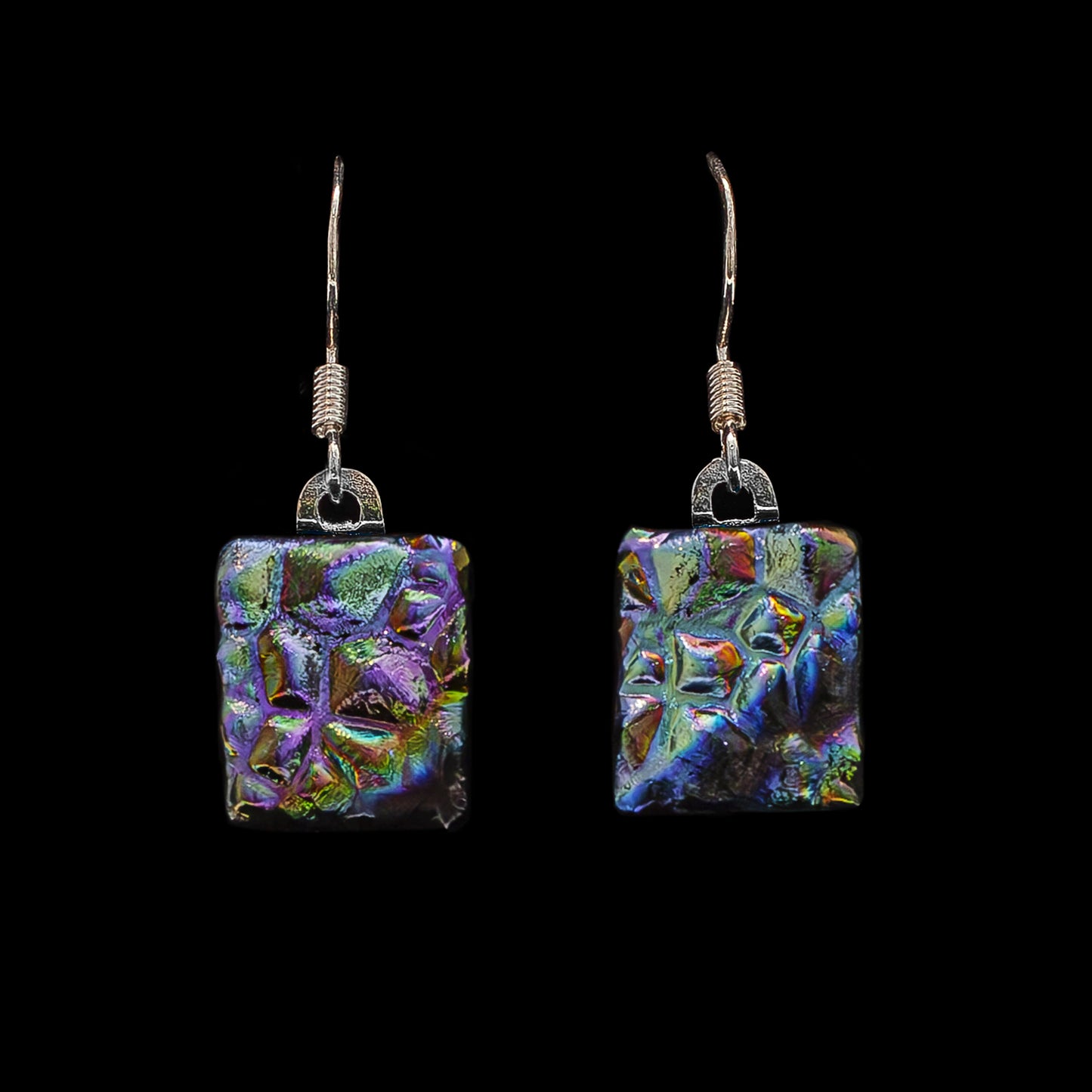Square drop earrings made from dichroic glass in vibrant peacock colours – artisan jewellery by Invoke London.