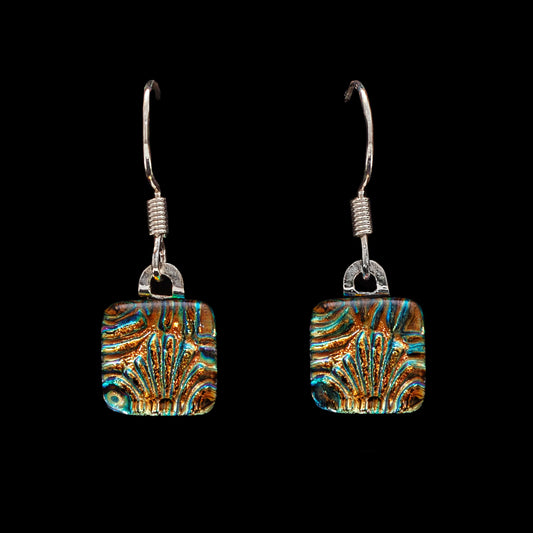 A pair of square-shaped, gold-florentine patterned drop earrings with dichroic glass, suspended from sterling silver hooks.