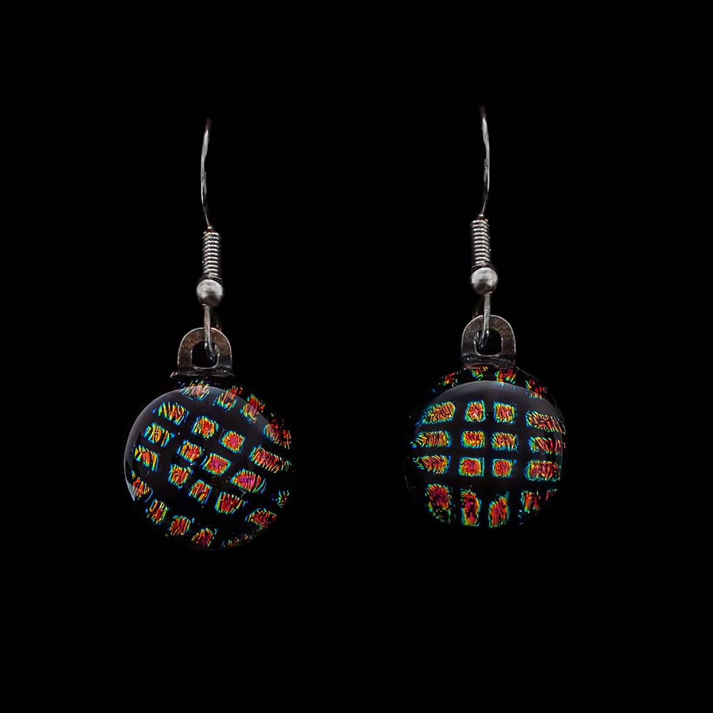 Round black dichroic glass drop earrings with red and gold square shimmer, handmade in London by Invoke London with sterling silver hooks.