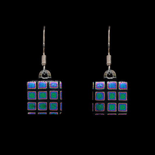 A pair of square dichroic glass drop earrings with black and blue patterns, attached to 925 sterling silver hooks.