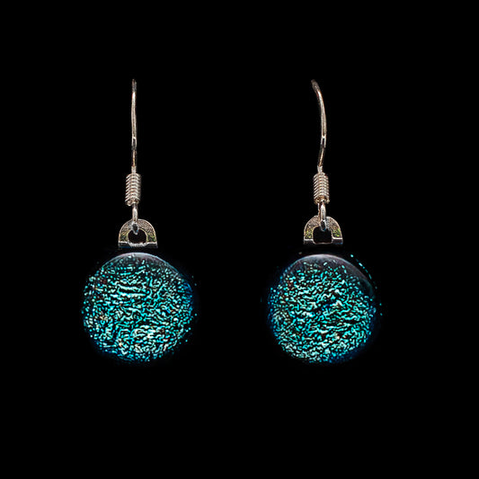 Round light blue dichroic glass drop earrings with shimmering texture and silver hooks. Handmade Luna Birthstone by Invoke London.