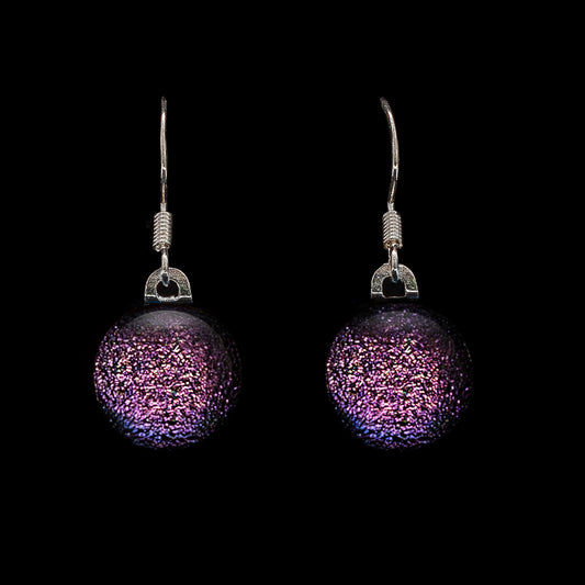 A pair of dark pink dichroic glass drop earrings with round cabochons, encased in clear glass and suspended from 925 sterling silver hooks.