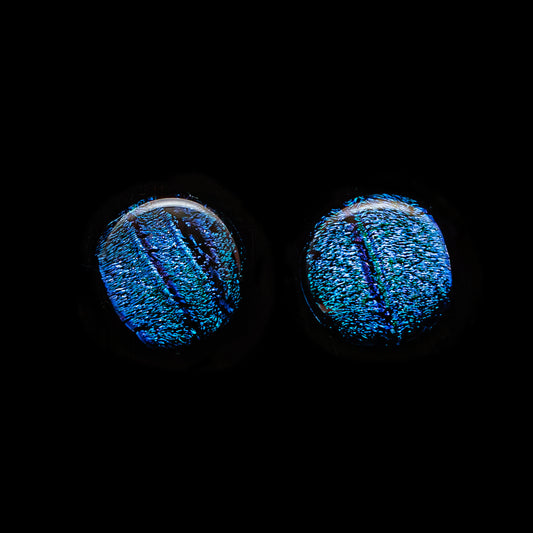 Round blue striped dichroic glass stud earrings with radiant summer shimmer, handmade in London by Invoke London with sterling silver posts.
