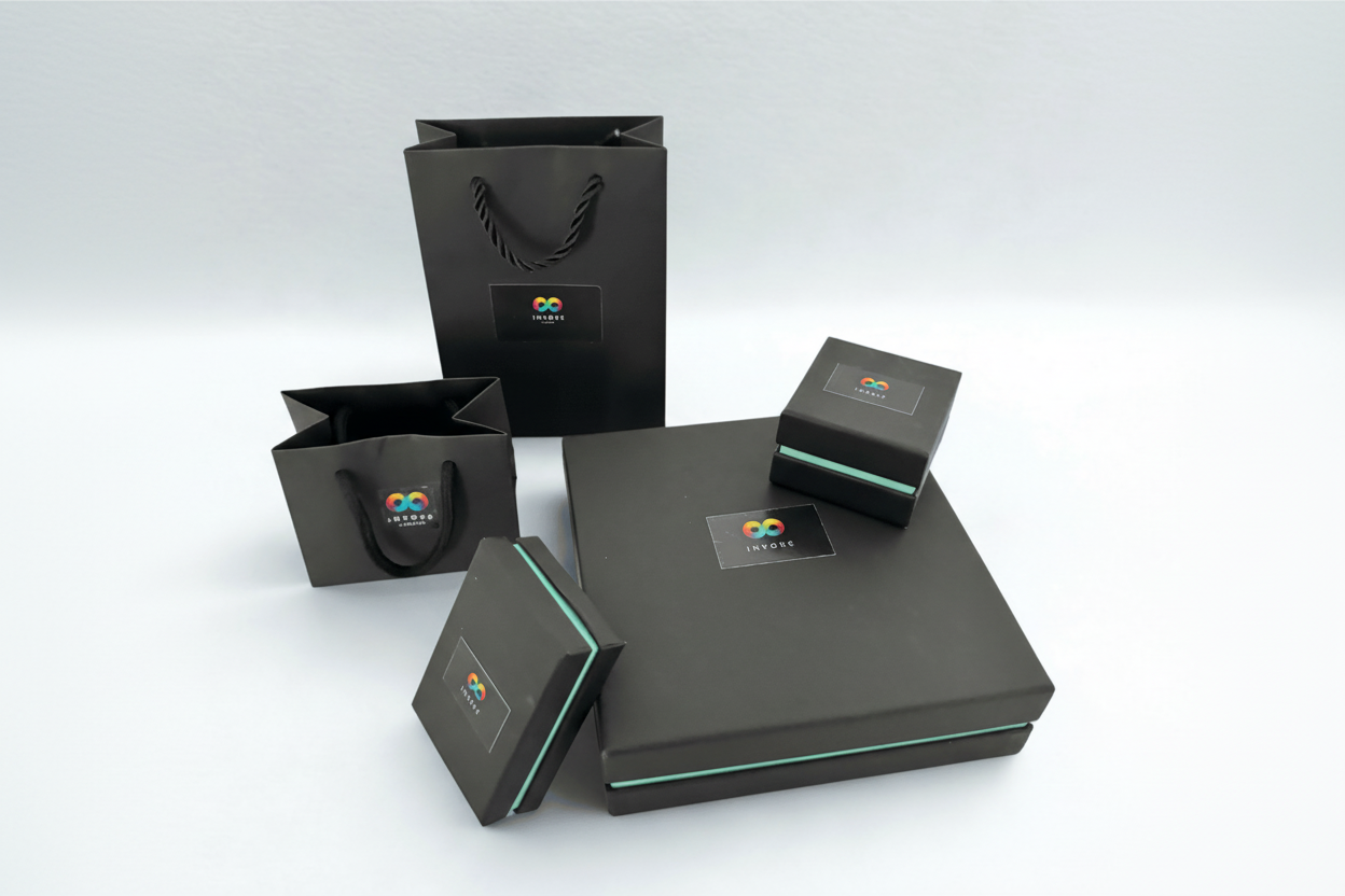 Sustainable black jewellery boxes and gift bags with Invoke London logo and teal edge detail, ideal for gifting handmade glass jewellery.