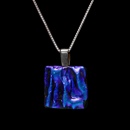 A square-shaped, dichroic glass pendant necklace in green and blue ripples, attached to a sterling silver chain.