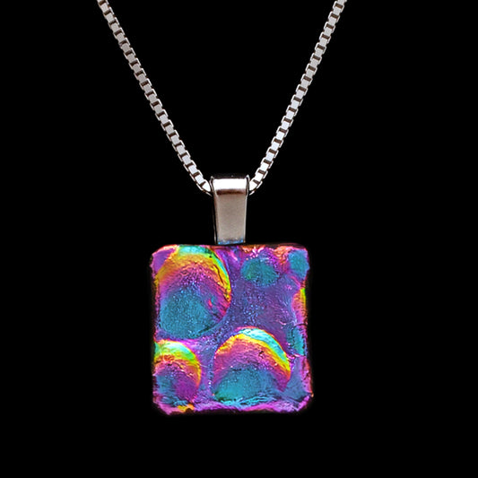 Square pink and blue dichroic glass pendant with bubble texture on a silver chain. Handmade in London by Invoke London.