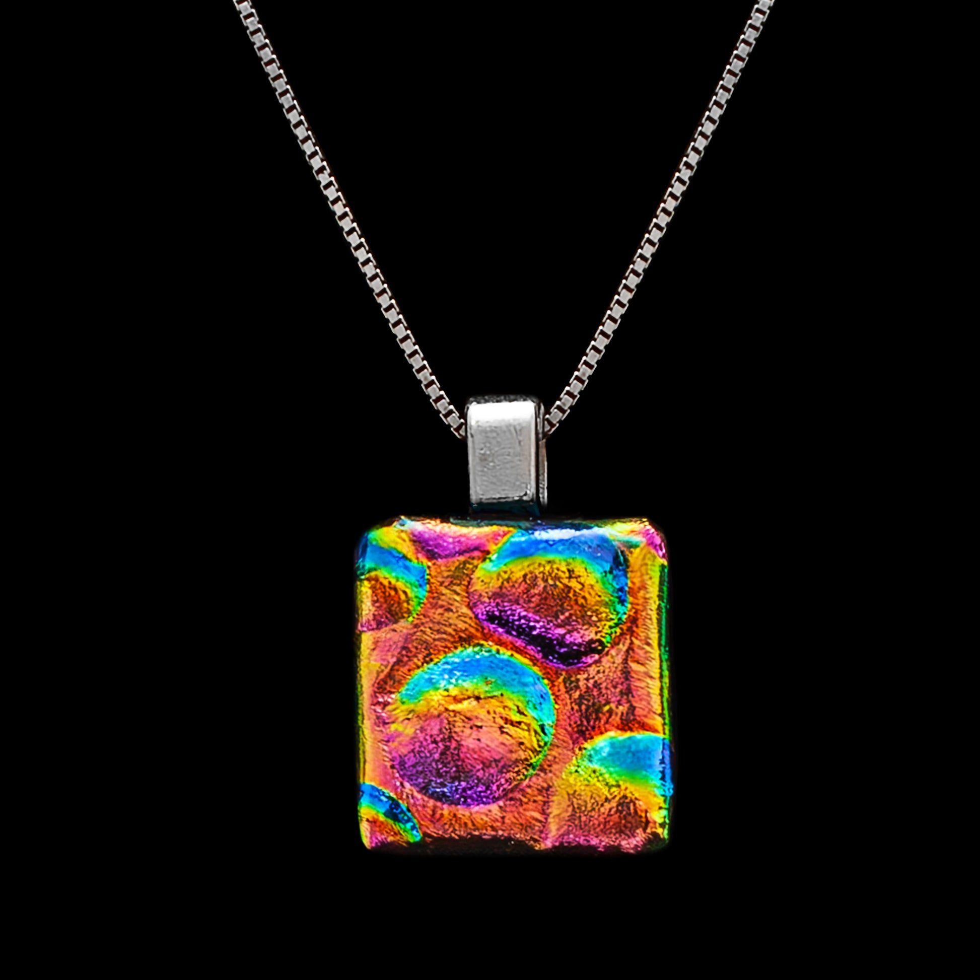 Square gold, pink, and blue dichroic glass pendant with bubble texture on a silver chain. Handmade in London by Invoke London.