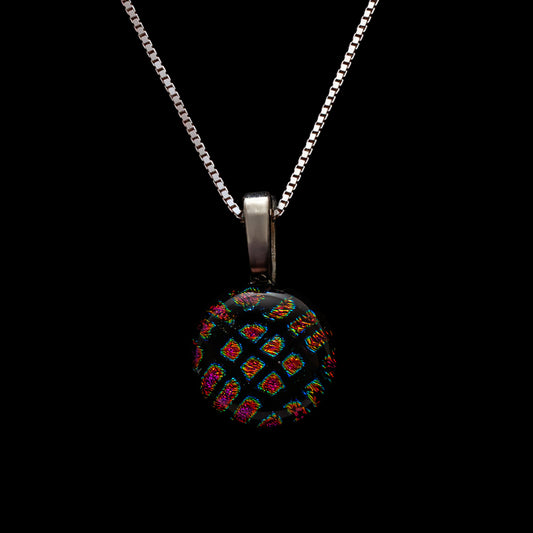 Round black dichroic glass pendant with red square shimmer on a sterling silver chain, handmade in London by Invoke London.