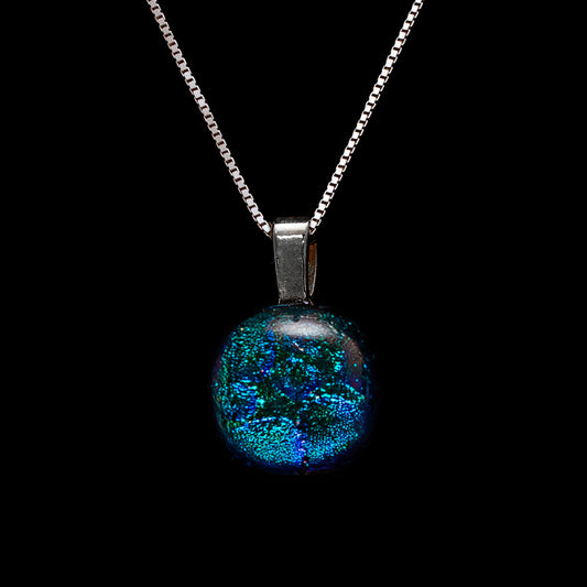 A round dichroic glass pendant necklace in blue/green dew drop color, with a sterling silver chain.