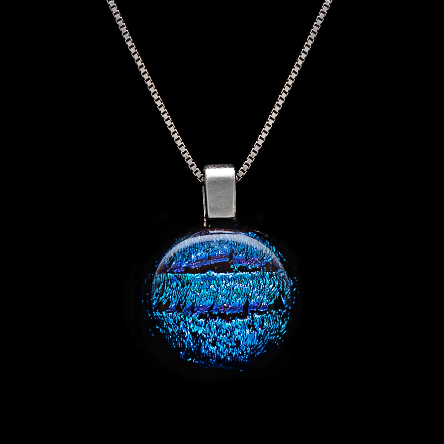 Round blue striped dichroic glass pendant necklace with shimmering texture, handmade in London by Invoke London on a sterling silver chain.