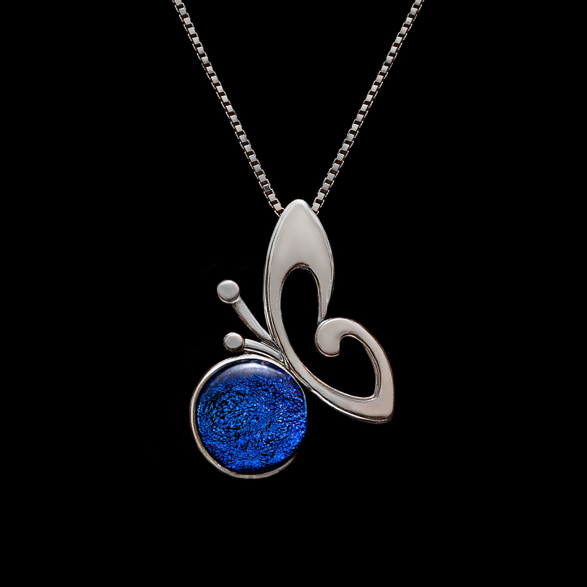 Blue dichroic glass butterfly necklace on a silver chain, handmade in London by glass artist Madiha Zaidi.