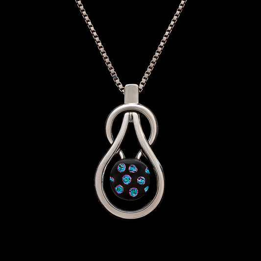 Handmade Stella necklace featuring a teardrop knot and a black dichroic glass pendant with shimmering blue spots, by Madiha Zaidi.