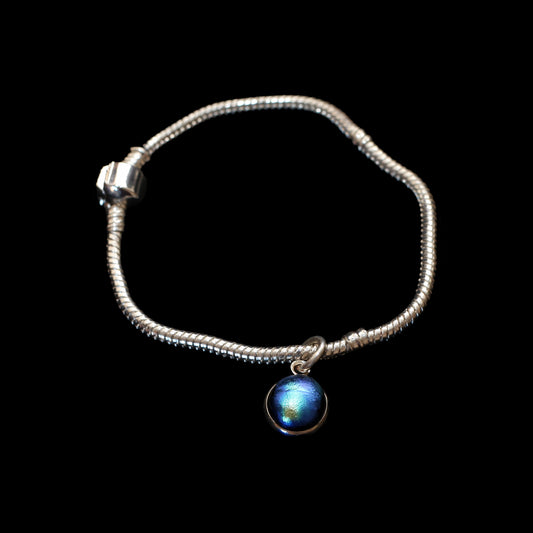 Silver bracelet with a blue gemstone charm on a black background