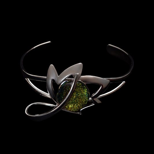 Silver bracelet with a green dichroic handmade stone on a black background