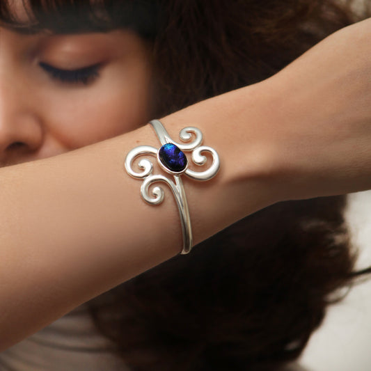 Silver bracelet with a blue gemstone on a person's wrist