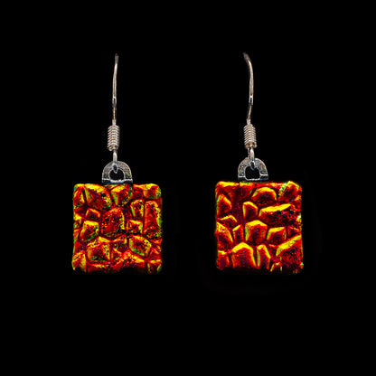 Square red-orange dichroic glass drop earrings with shimmering detail. Handmade from the Astra Collection by Invoke London.