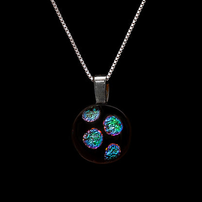 Necklace with a round, green dots pendant on a black background