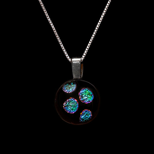 Necklace with a round, green dots pendant on a black background