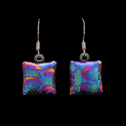 Square dichroic glass drop earrings in pink and blue with bubble texture. Handmade in London by Invoke London with sterling silver hooks.