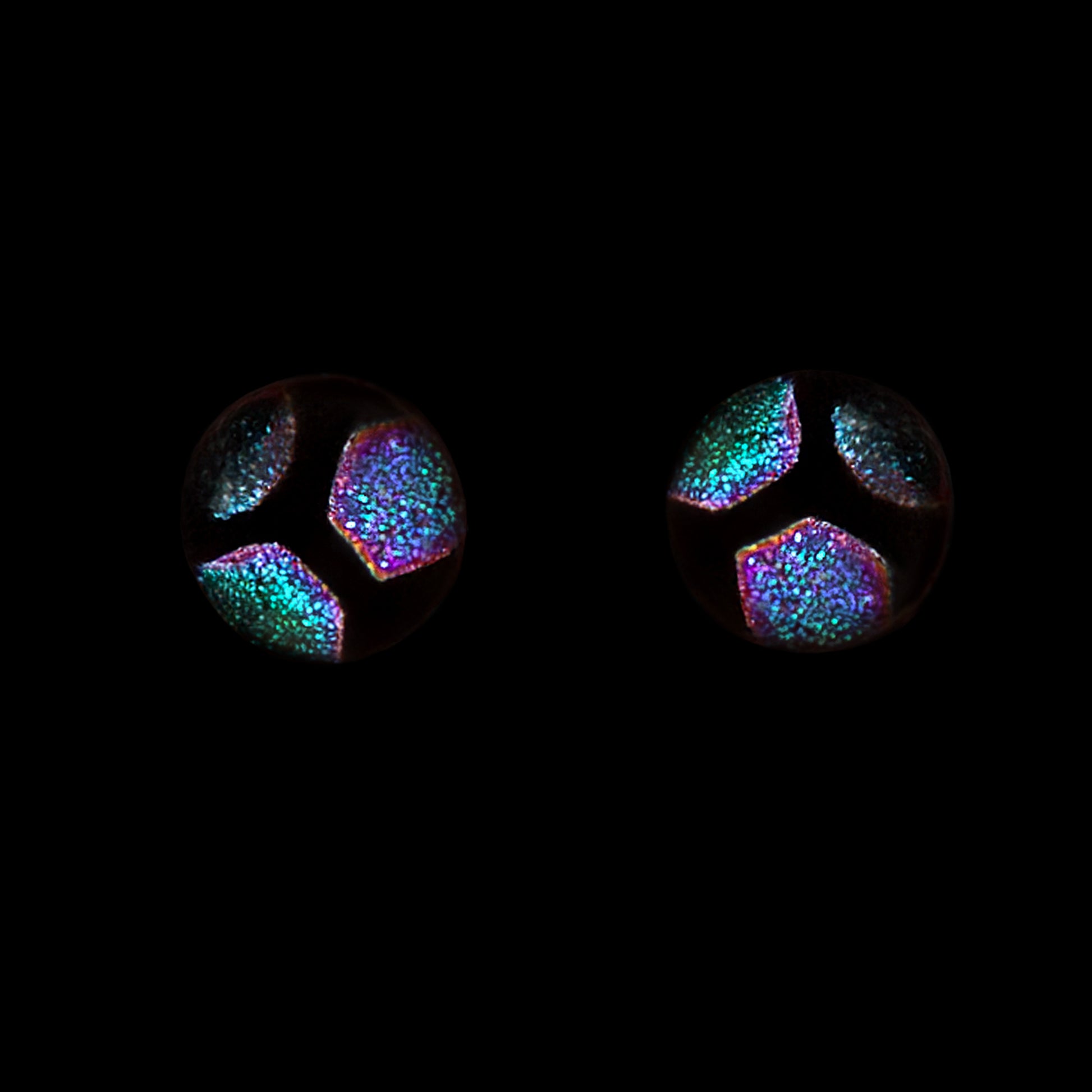 Green hexagon stud earrings on a black background