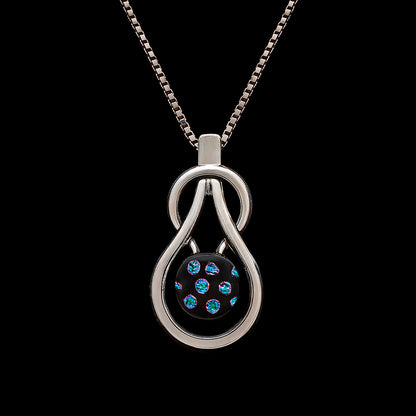 Handmade Stella necklace featuring a teardrop knot and a black dichroic glass pendant with shimmering blue spots, by Madiha Zaidi.
