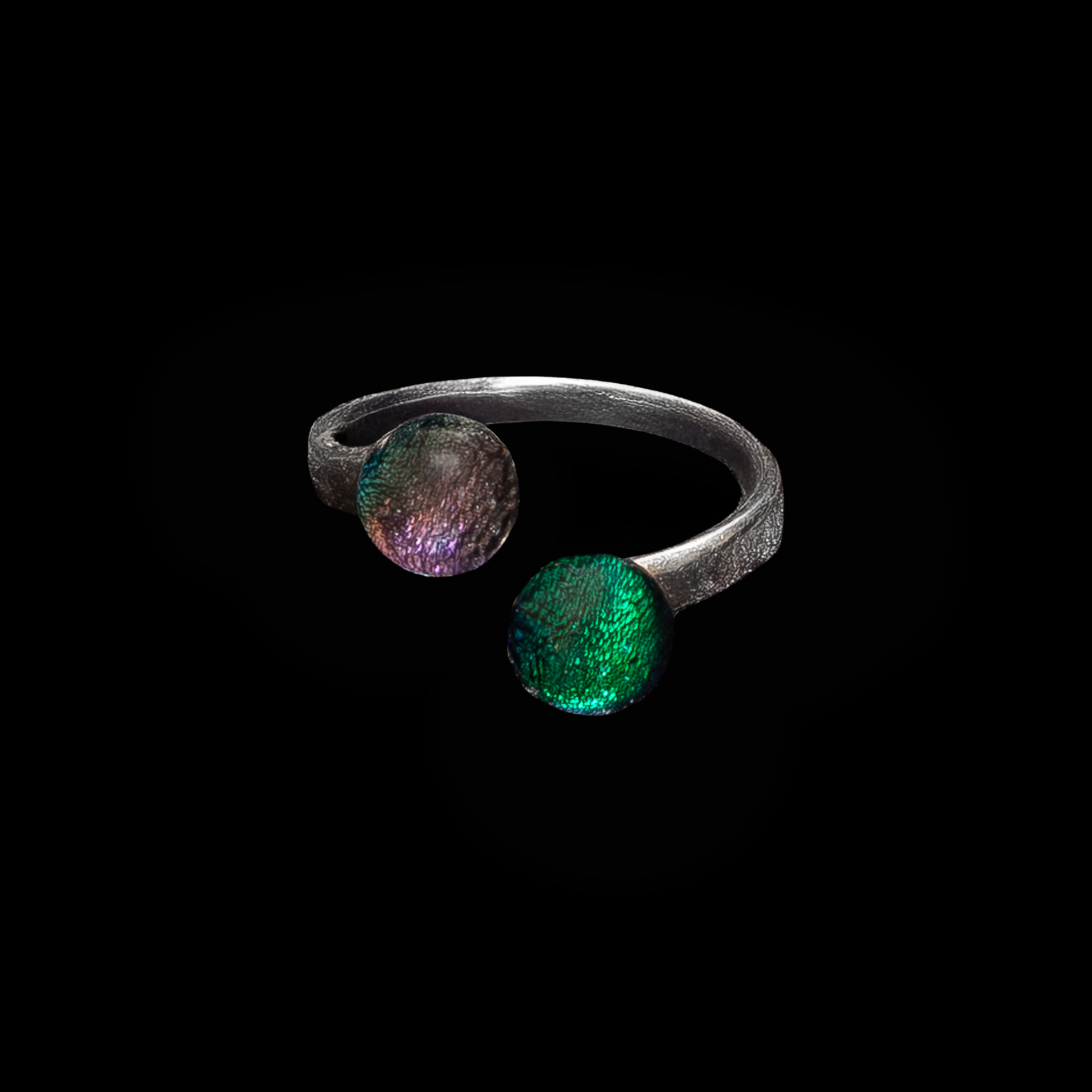 Silver ring with two gemstones in pink and green on a black background