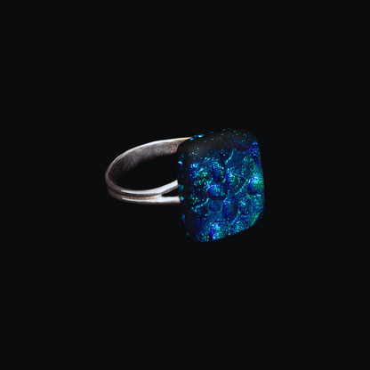 Ring with a blue textured stone on a black background