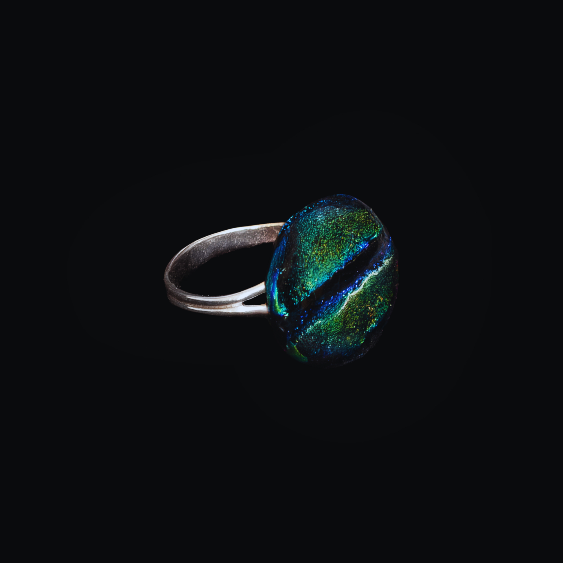 Ring with a colorful gemstone on a black background
