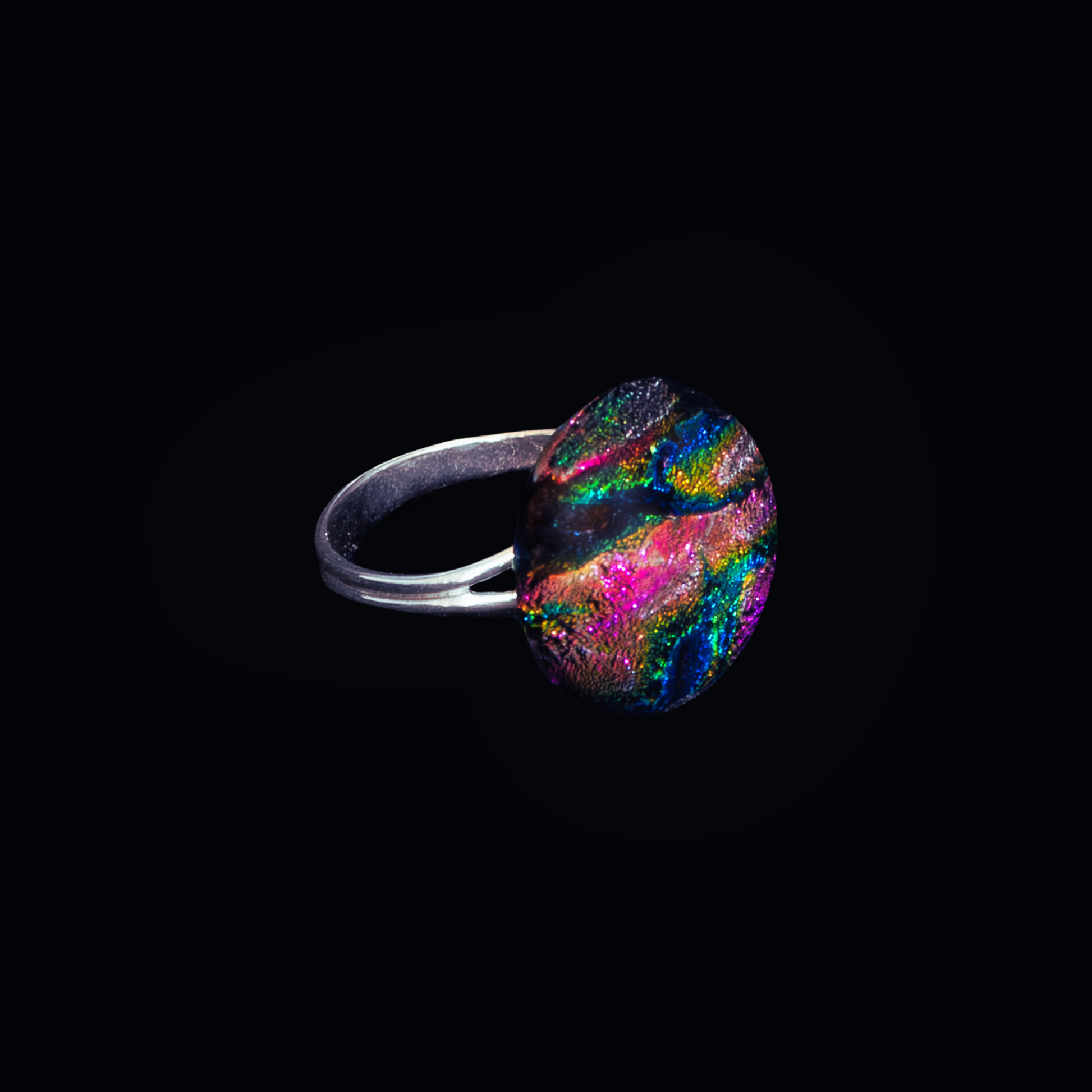 Ring with a colorful gemstone on a black background